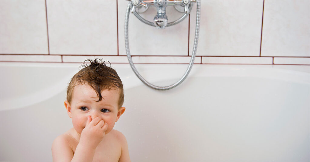 San Leandro plumbers and smelly drains blog featured image showing baby holding nose in bath tub.
